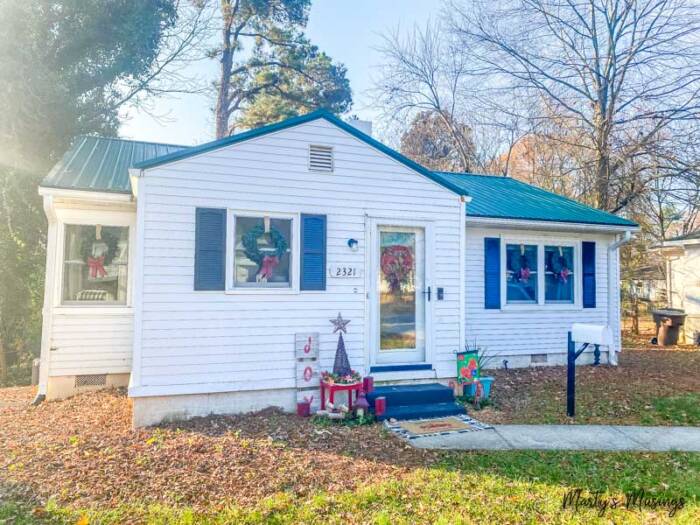 white cottage home with green metal roof