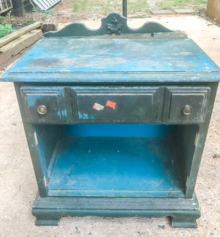 Beat up blue night stand with missing drawer