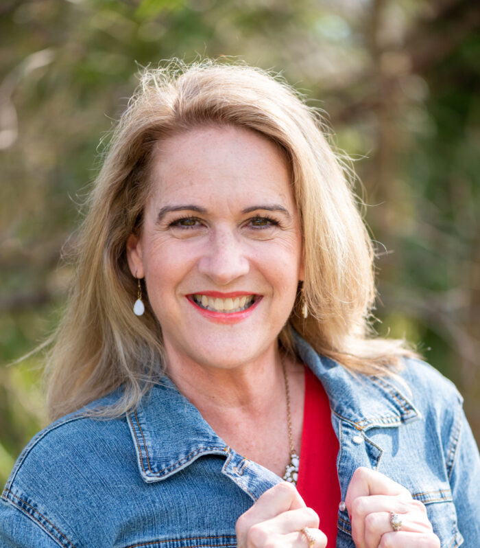 Blond older woman with jean jacket and red shirt