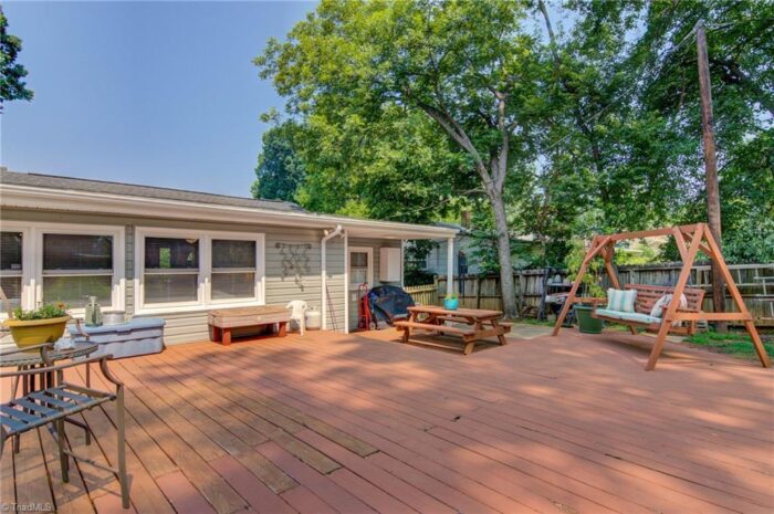 Large back deck with swing set and picnic table