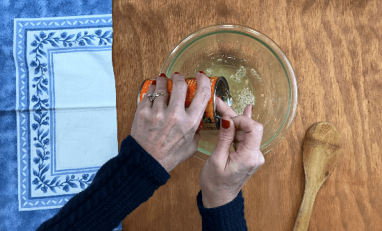 Drain canned mandarin oranges into glass bowl