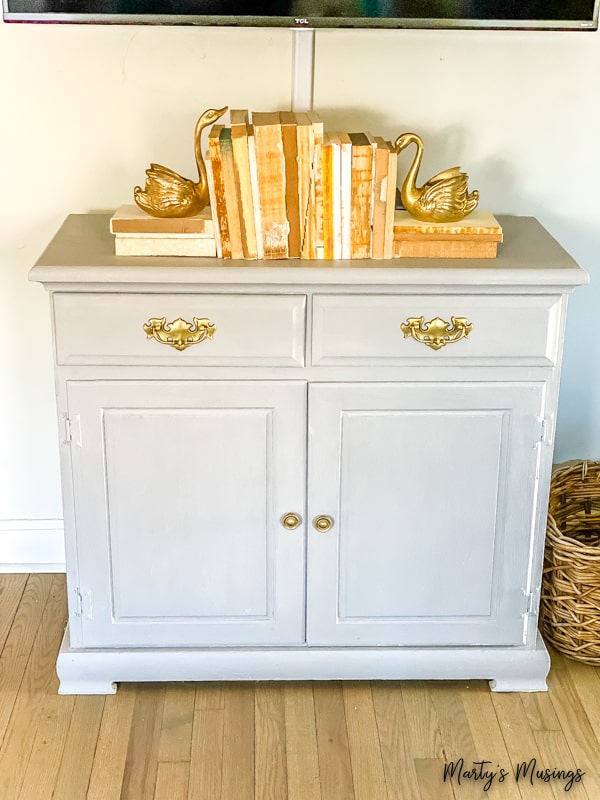Gray chalk painted chest with old books and geese on top