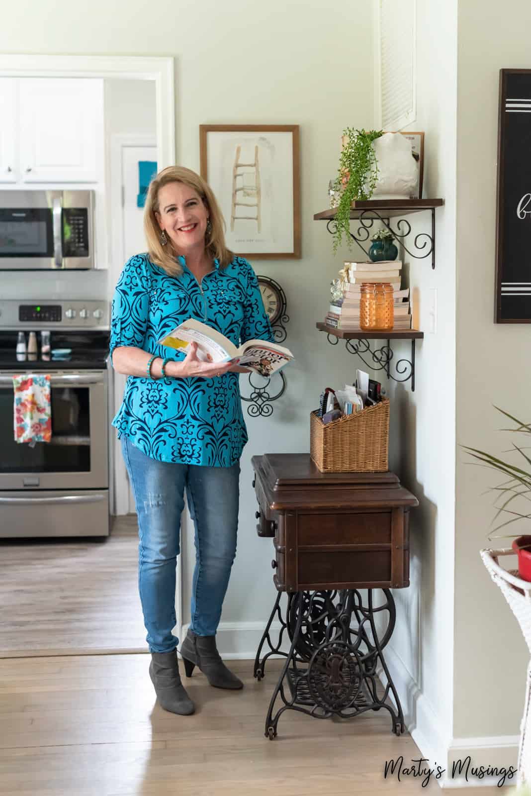 woman in blue patterned shirt and jeans in front of book shelves