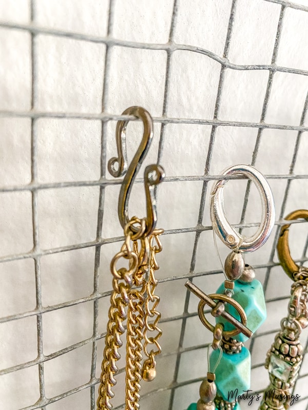 s hooks used to hang necklaces on wooden frame