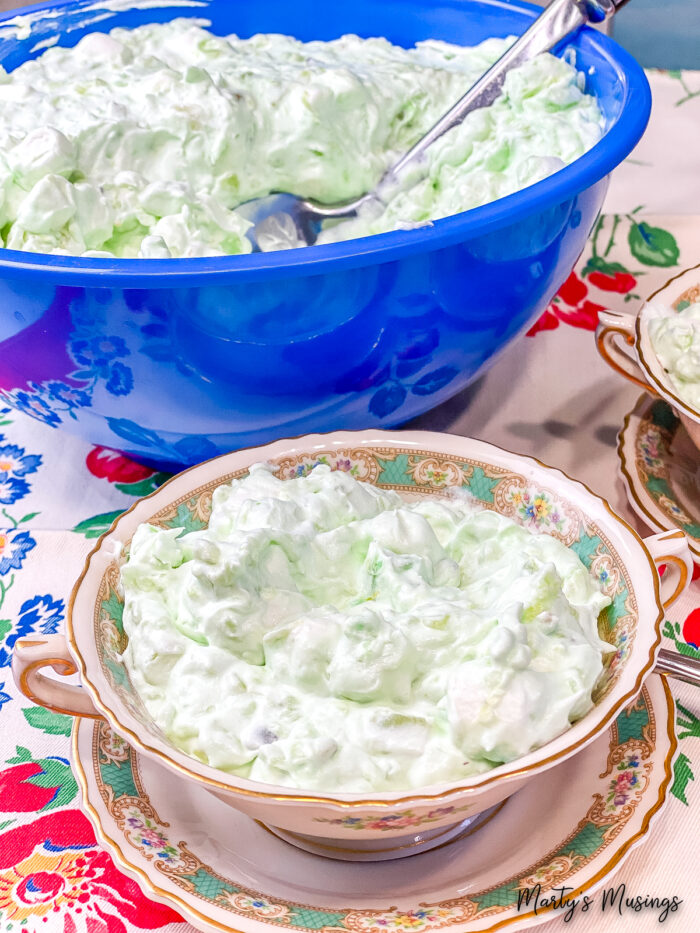 Green dessert in blue bowl and vintage cups