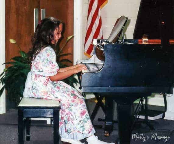 Young girl in floral dress playing the piano