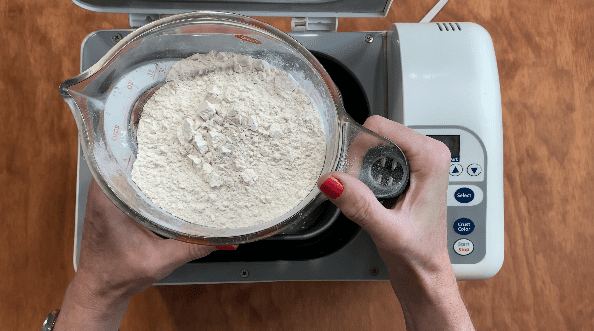Pour flour into bread machine to make white bread