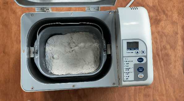 Start bread machine by closing door and choosing settings.