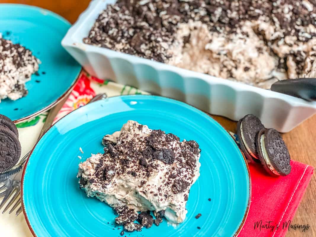 Oreo dirt cake on blue plate with dish in background