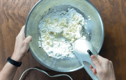 Hand held mixer beating dough ingredients