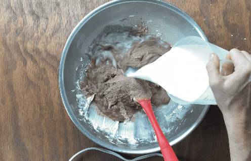 Add milk to dough mixture in metal bowl