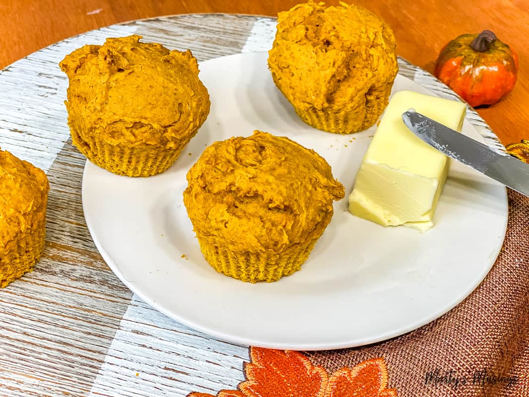 pumpkin muffins on white plate with butter