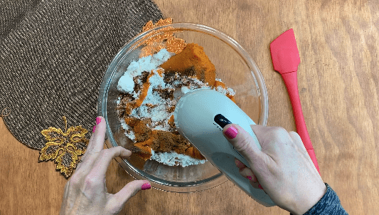 Use hand mixer to beat ingredients for pumpkin muffins