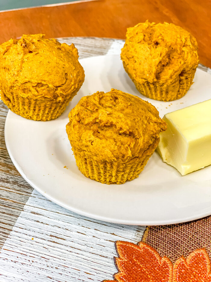 Pumpkin muffins on a white plate with butter