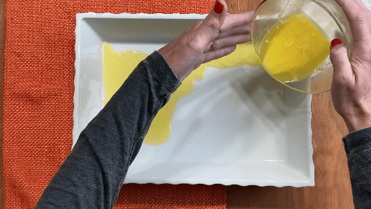 pour melted butter into white casserole dish