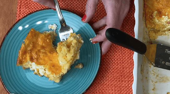 Jiffy corn casserole with cheese on blue plate