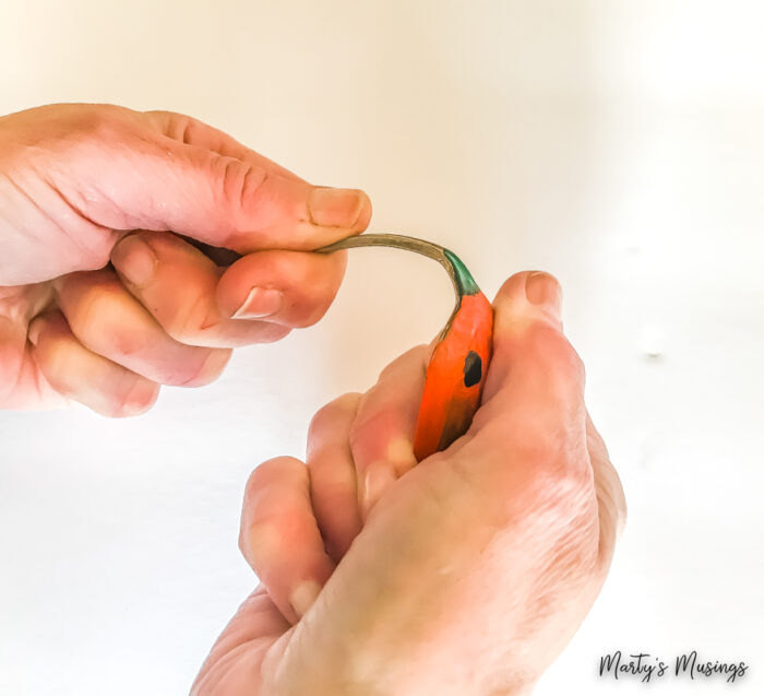 Bending painted pumpkin spoon in half