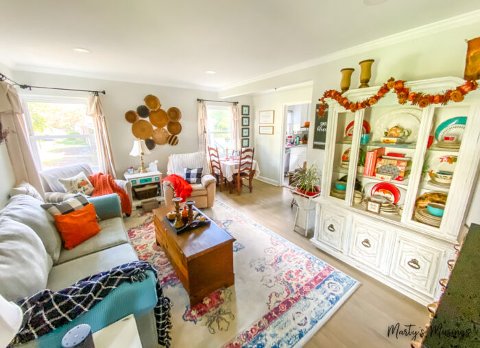 Living room decorated for fall with orange and black plaid accents