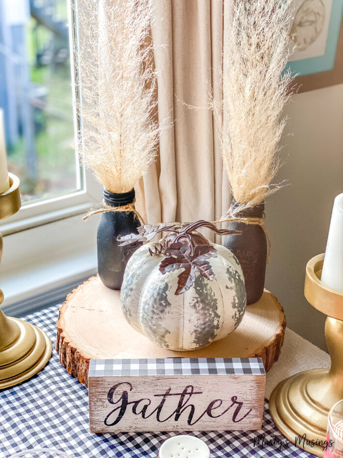 Round wood block with silver pumpkin and black bottles