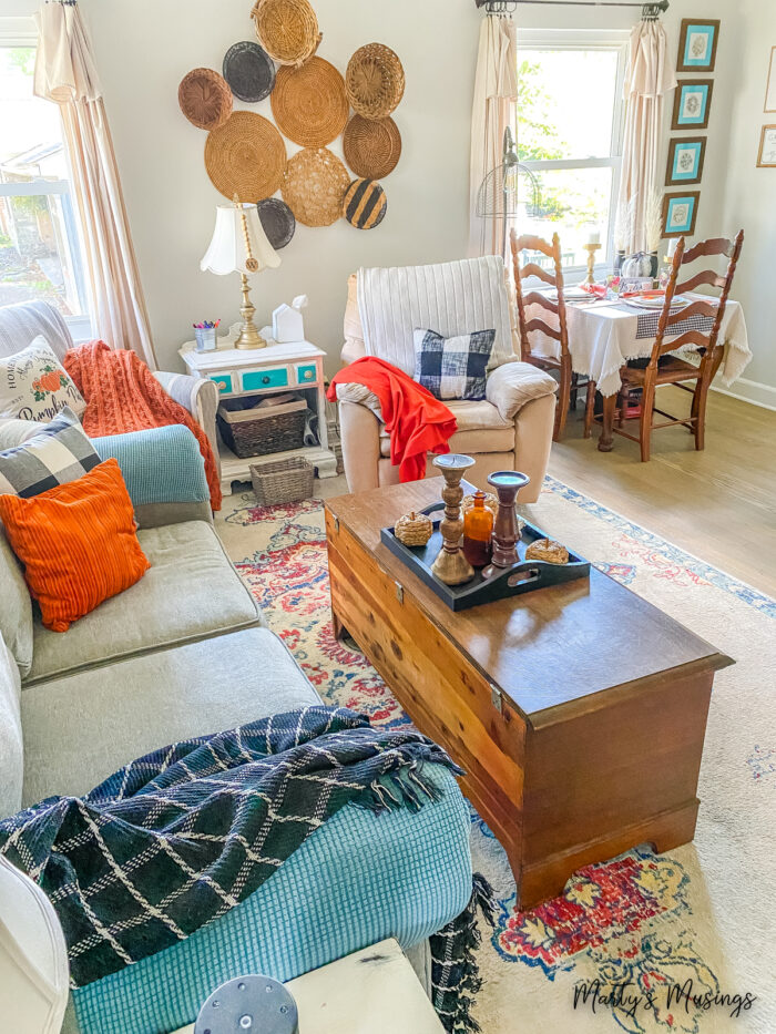 Living room decorated for fall with orange and black plaid accents