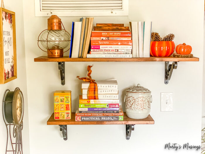 Wooden shelves with cookbooks and fall decorations