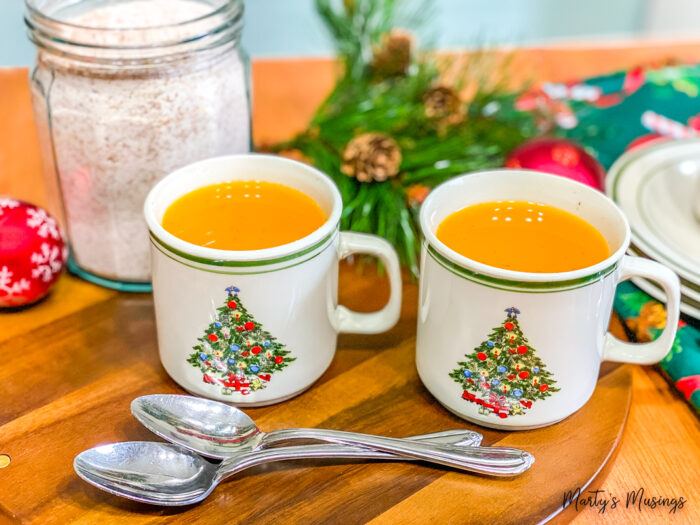 Two Christmas mugs of orange tea
