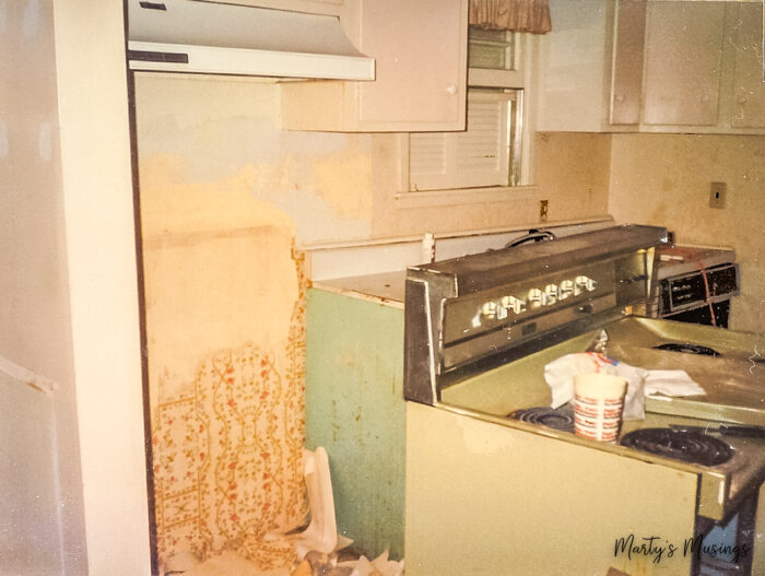 Peeling wallpaper behind kitchen stove in old home