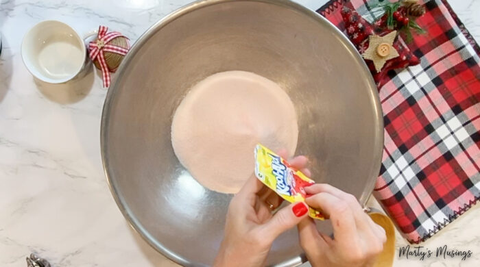 Adding lemonade mix to large metal bowl