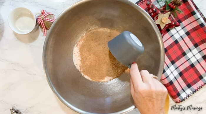 Adding powdered instant tea to metal bowl mixture