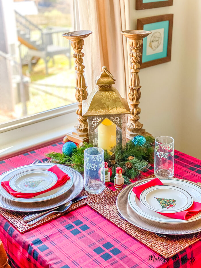 Christmas table with red plaid tablecloth and gold accessories