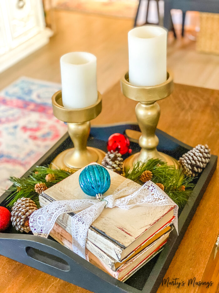 Black tray with old books and gold candle holders