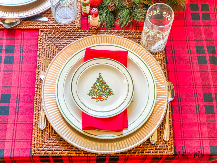 Black and red plaid tablecloth with gold charger and Christmas dishes