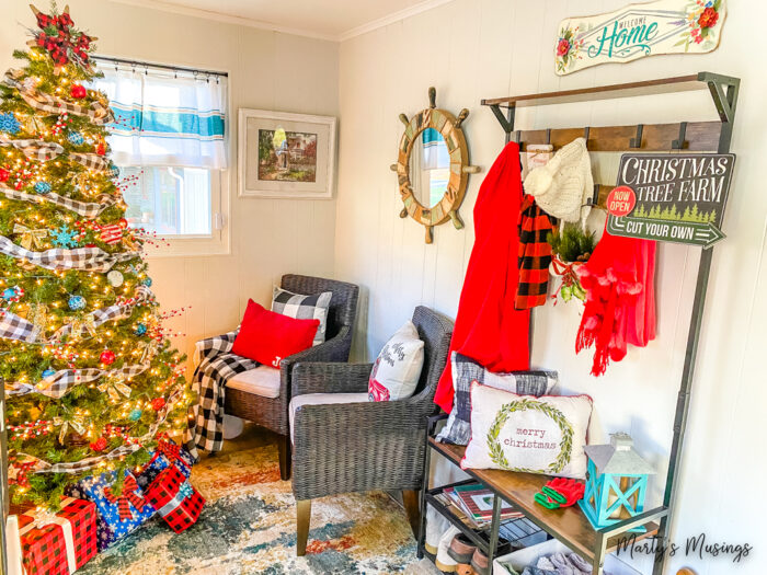 Sunroom with Christmas tree, black chairs and wooden hall tree