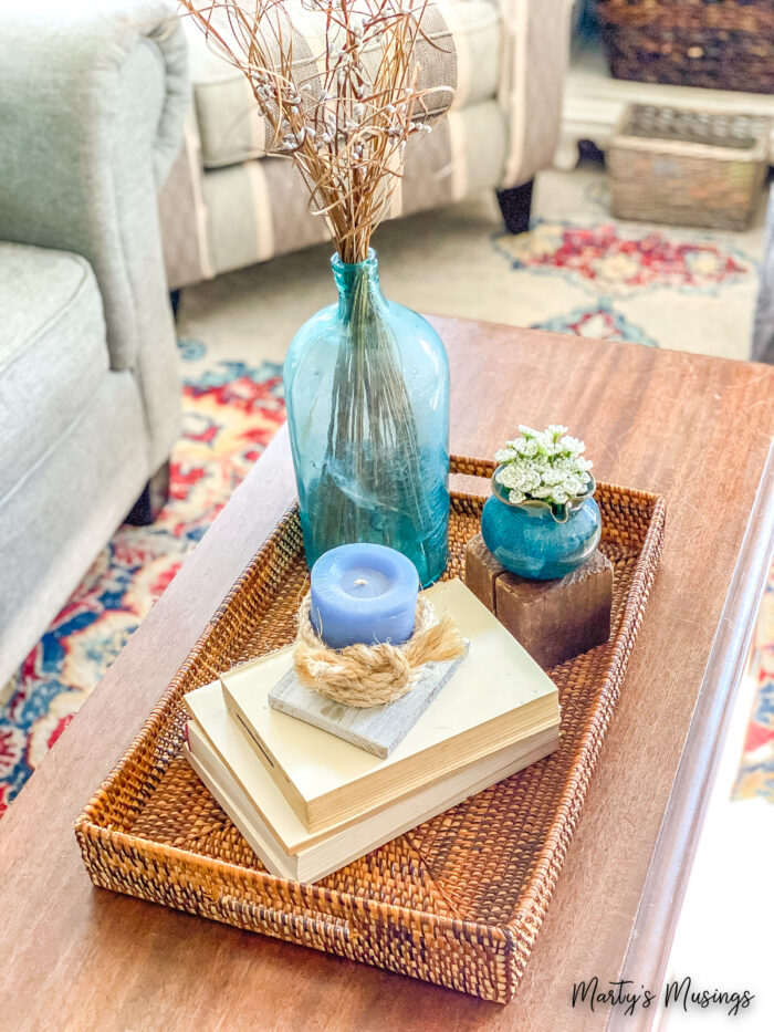 Small vignette with woven tray, books and blue accessories