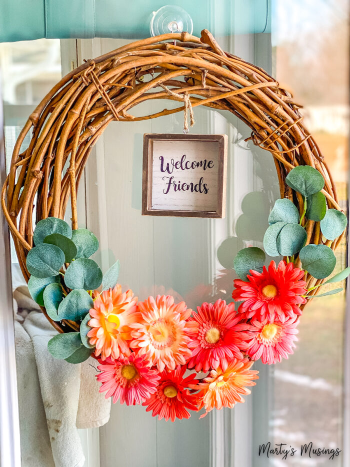 grapevine wreath with orange flowers and welcome friends sign