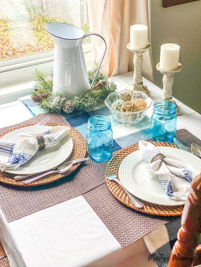 Blue throw used with blue accents and white china on small kitchen table