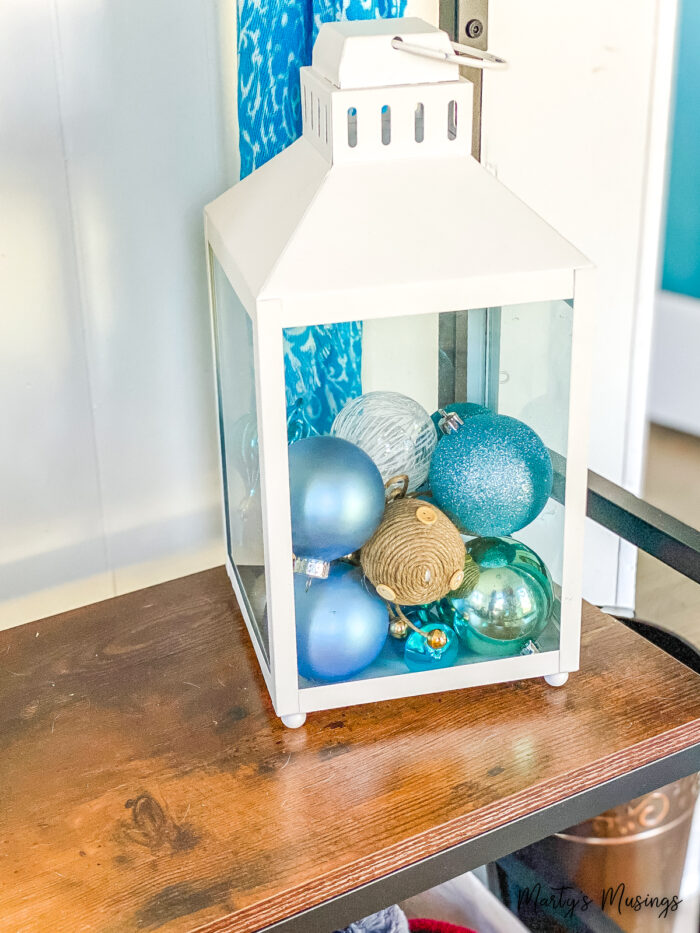 white lantern filled with blue and white ornaments and balls