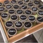 spices in kitchen drawer with black chalkboard lids