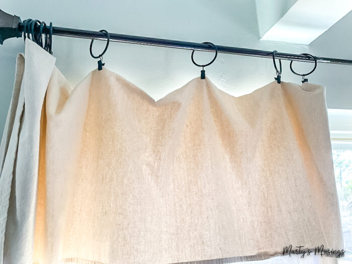 Drop cloth curtains hung on black rod