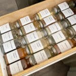 Drawer in kitchen filled with spice jars with white labels