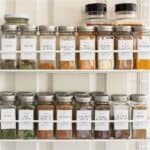Hanging wire rack filled with spice jars and white labels