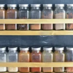 wooden spice rack holding several matching jars of spices
