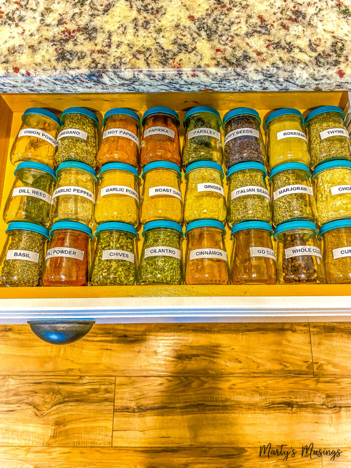 Drawer filled with labeled baby food jars for spices