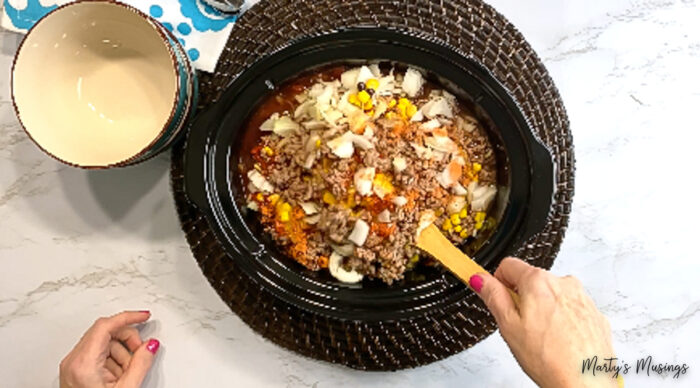 Stir ingredients for taco soup in slow cooker