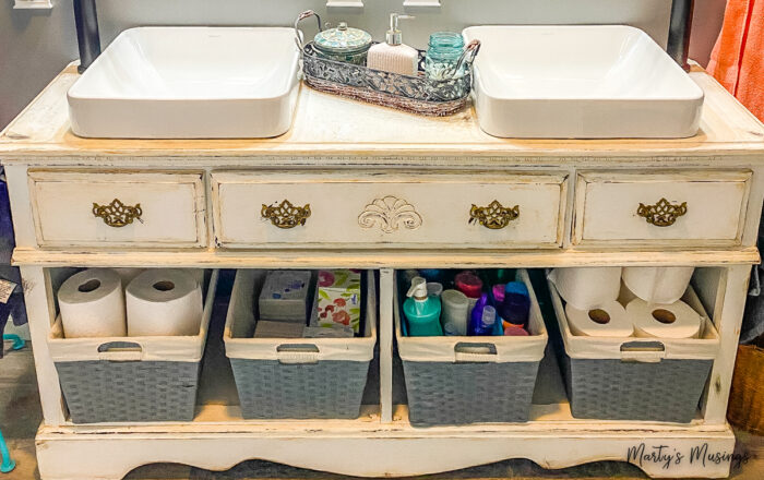 Distressed chest used as vanity for two sinks with open shelving