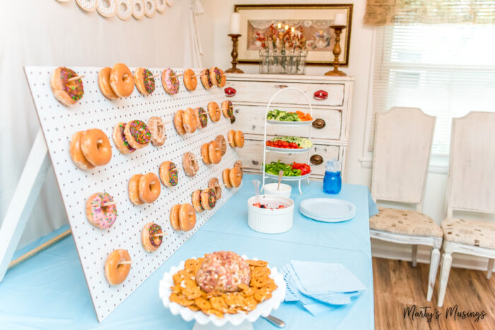 Side view of donuts hanging from pegboard with other snacks for party
