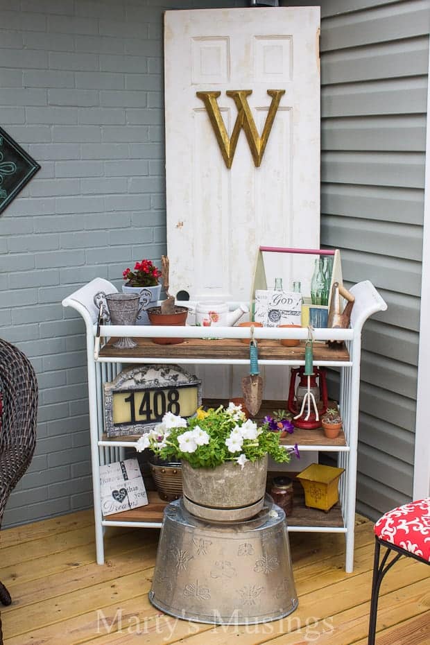 Deck with shelves and old wooden door behind outdoor decor