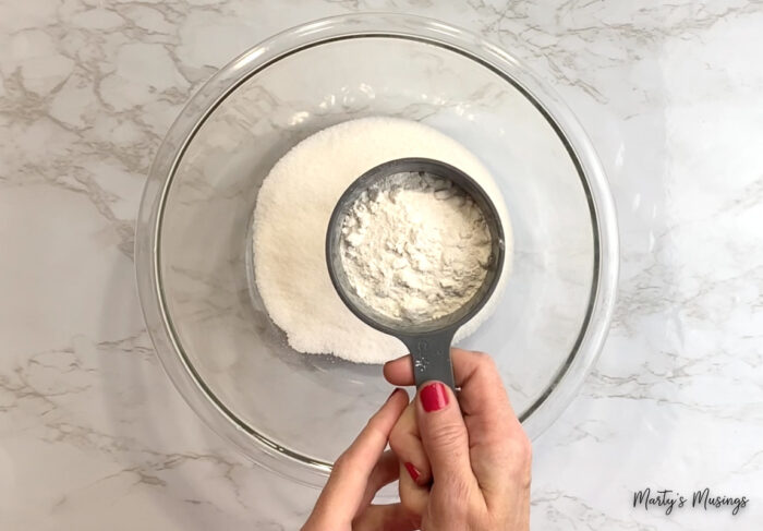 Add flour to sugar in glass bowl
