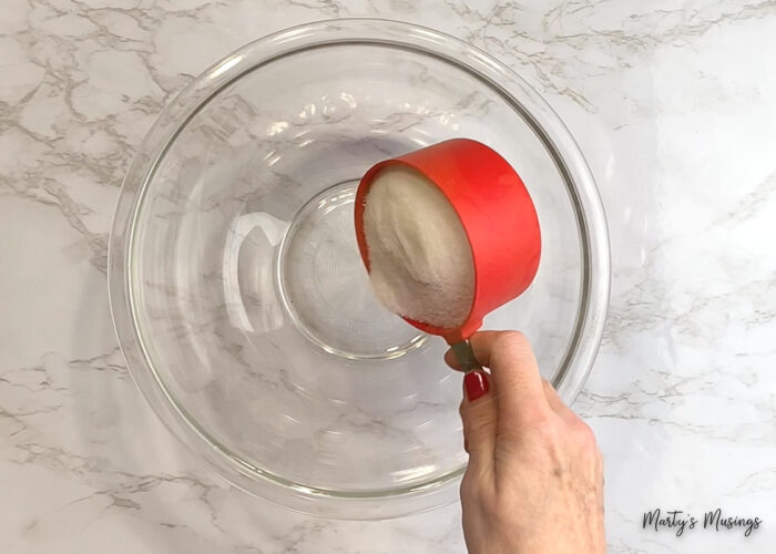Add sugar to glass mixing bowl
