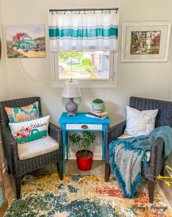 Small colorful nook with tea towels and bright pillows and pictures